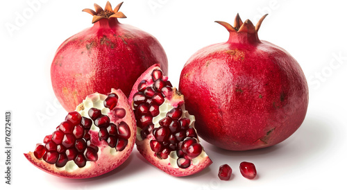 Two whole pomegranates and two cut halves isolated on white background