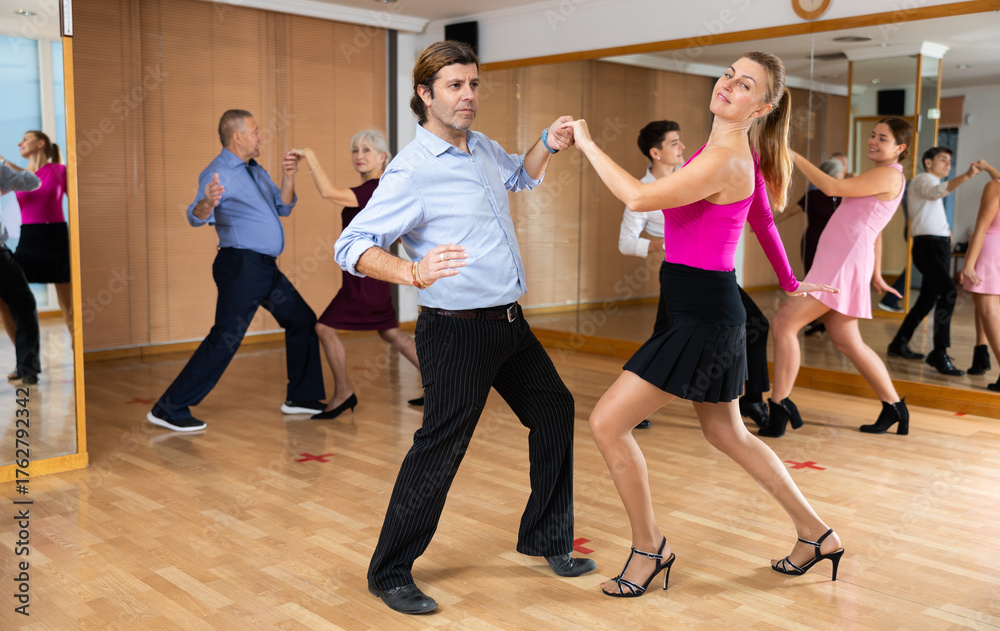 Fototapeta premium Happy couple performing a paired ballroom dance in ballroom