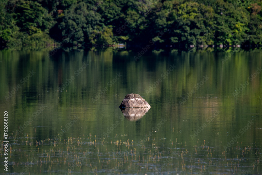 Fototapeta premium Reflections of rocks and forests on the quiet surface of Lake Onuma