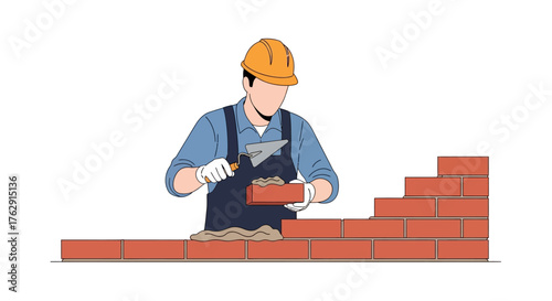 A construction worker wearing a helmet lays bricks to build a wall