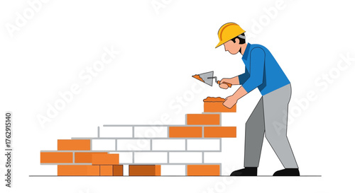 A construction worker wearing a hard hat uses a trowel to lay bricks for a wall