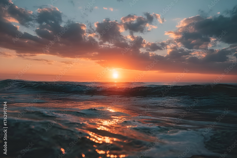 Obraz premium A stunning sunset over a tranquil ocean, with vibrant colors reflecting on the gentle waves, creating a serene atmosphere.