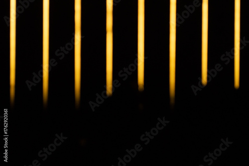 Líneas verticales de luz amarilla sobre fondo negro