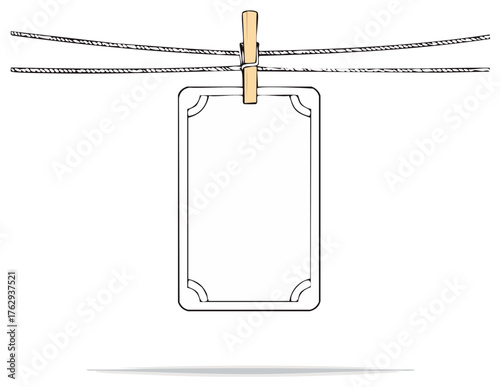 Blank vertical sign card with rounded corners hanging on a clothesline, held by a wooden clothespin