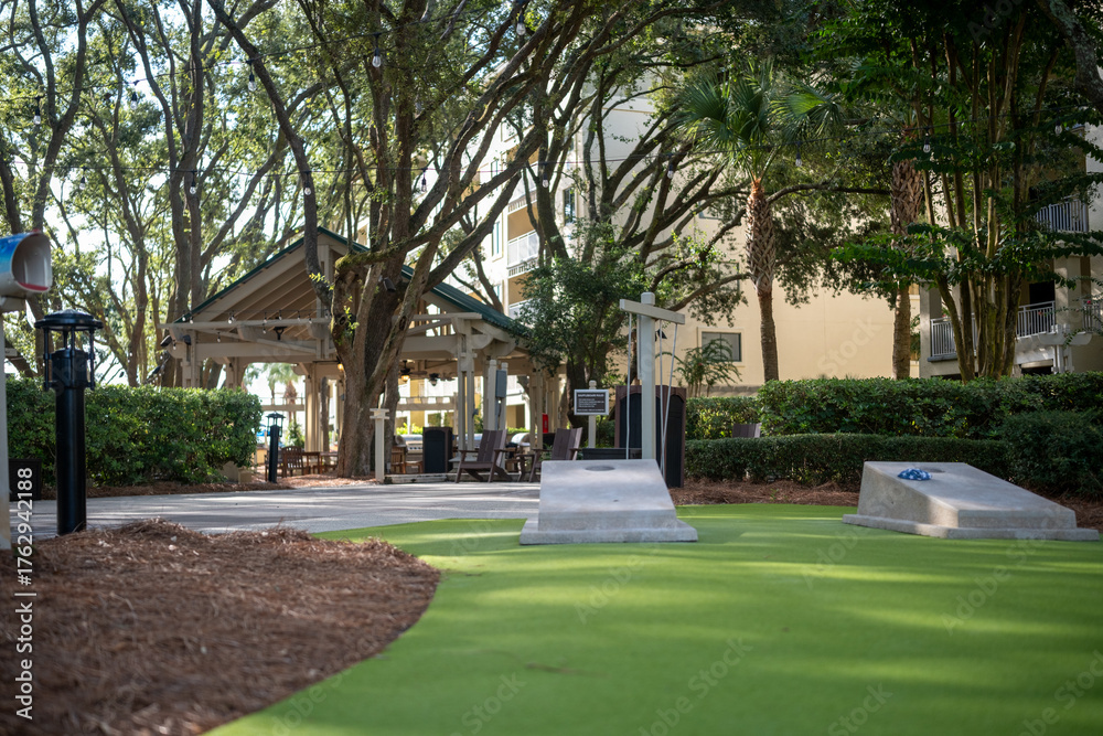 Obraz premium Outdoor miniature golf area in a lush setting surrounded by trees and a gazebo