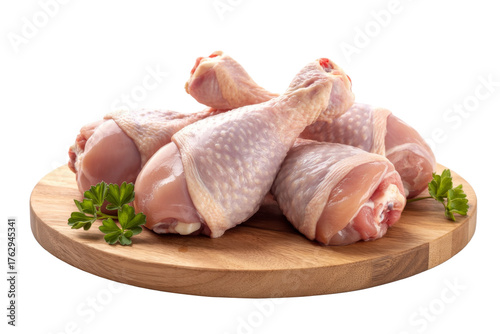 raw chicken drumsticks on wooden board, isolated.