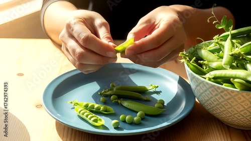 Hands delicately shelling fresh green peas on a wooden table