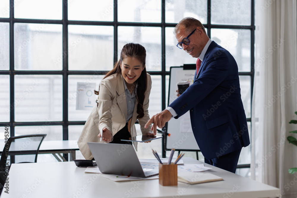 Fototapeta premium Team of multiethnic professionals sharing conversation in office. Happy business team laughing and engaging in a casual discussion. Group of business people in meeting talking on business report. 