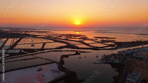 Aerial shot revealing the salt pans near Tavira and Fuseta in Ria Formosa natural park in Algarve region at sunrise with beautiful colors in the sky, Portugal