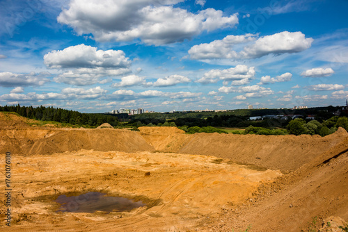 Obraz na plátně Vast open-pit quarry with rugged, excavated terrain and a murky puddle