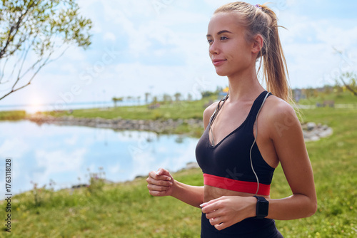 Smiling young woman jogging outdoors