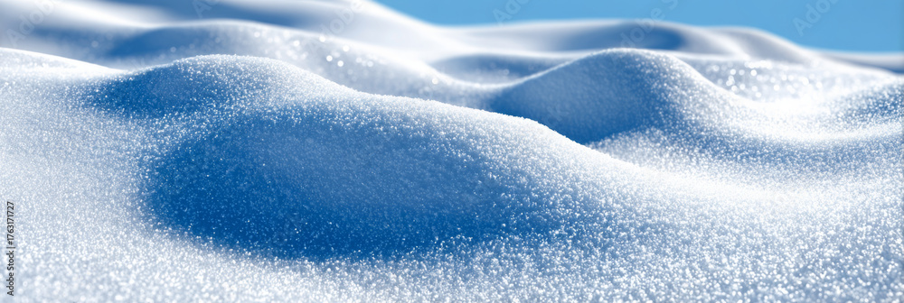 Obraz premium Snow-covered landscape with gentle undulating hills, showcasing a pristine winter scene under a clear blue sky, evoking tranquility and natural beauty in a serene environment