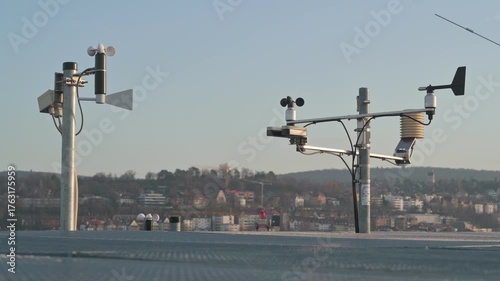 Weather Station on Rooftop Monitoring Climate and Air Pollution with Blurred City Skyline in the Background
