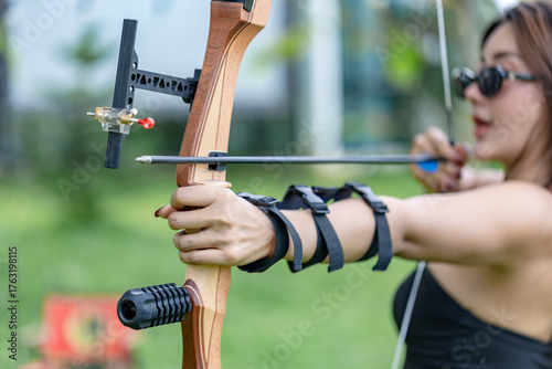 Close-up of Woman Archer Drawing Arrow with Bow Sight and Arm Guard