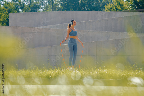 Fitness enthusiast skipping rope in vibrant outdoor setting during a day