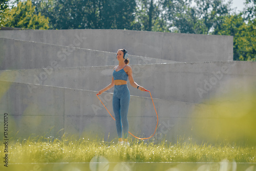 Outdoor fitness session with a woman skipping rope in a vibrant green field