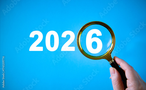 New Year's Eve concept with numbers 2026 under a magnifying glass in hand