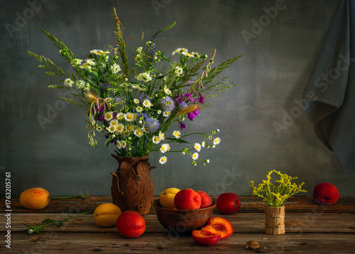 Still life with a bouquet of meadow flowers and ripe and sweet fruits.