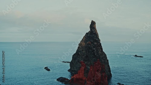 Towering volcanic sea stack rising from atlantic ocean near madeira island portugal shown in wide shot with dramatic rock textures