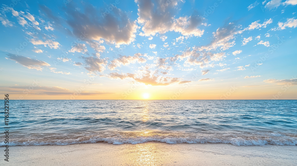 Obraz premium Sunset over calm ocean waves, with vibrant clouds reflecting warm hues