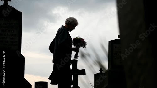 mujer anciana caminando entre lápidas en cementerio