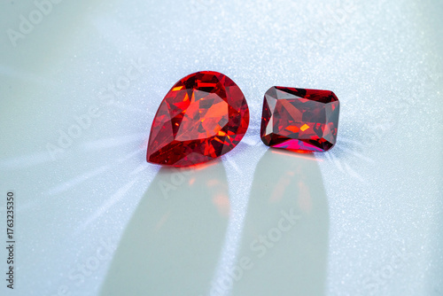 Foto Sparkling red gemstones with brilliant facets placed on a light background, symbolizing luxury, passion, and elegance, perfect for jewelry, fashion, or decorative design concepts
