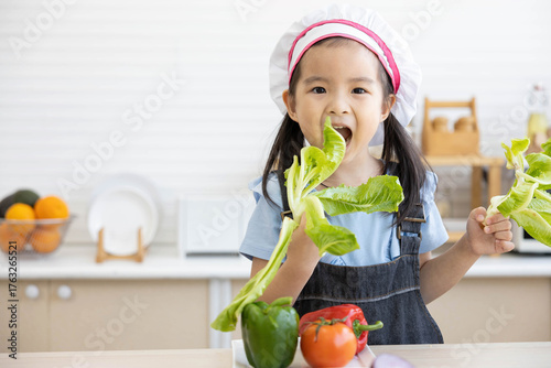 asian kid holding vegetables and preparing meal in the kitchen