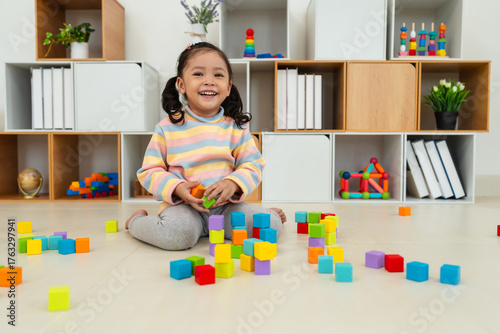 toddler girl playing block toy to stacks building cubes at home