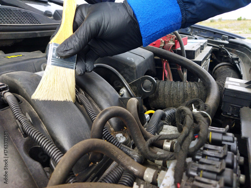 Fényképezés Cleaning engine parts with a brush in open air