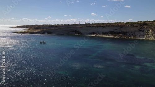 AERIAL drone shot: Limestone Wall of Ta Kalanka Sea Cave Bay with Turquoise Color Sea