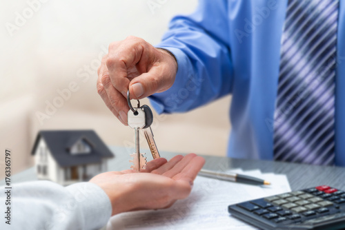 New homeowners receive keys to their dream house during a real estate closing transaction