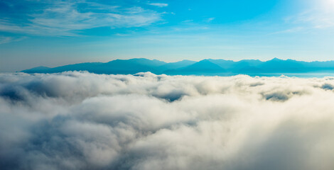 Keuken achterwand Mistige ochtendstond Wolkenzee boven bergtoppen onder blauwe hemel  © ABCDstock