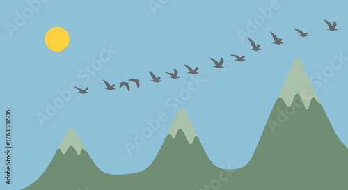 Flock of migrating birds flying over a mountain range.