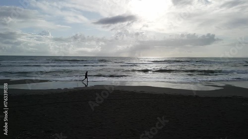 drone, vista su uomo che corre sulla spiaggia (jogging)