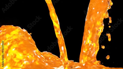 Vibrant orange liquid splashing and pouring against a stark black background creating dynamic abstract patterns and energetic motion with bright reflective surfaces.
