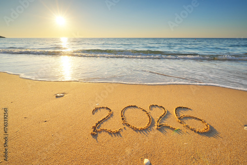 2026 text symbol of new year on the sea sand beach shore during sunset.
