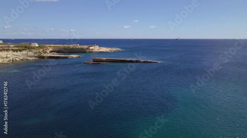 AERIAL drone shot: Limestone Wall of Ta Kalanka Sea Cave Bay with Turquoise Color Sea