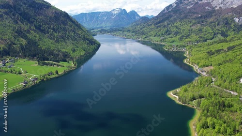 Experience breathtaking aerial views of Grundlsee Lake in Austria, showcasing its clear waters, lush landscapes, and majestic mountains. Nature beauty in one spectacular shot.