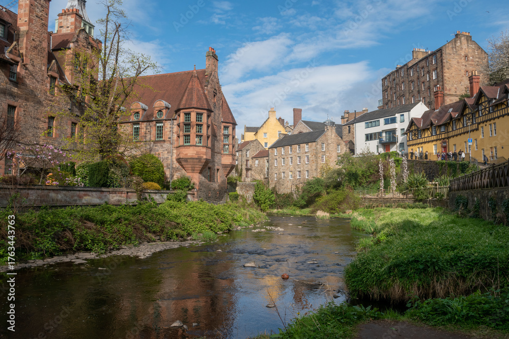 Naklejka premium Scenic view of Dean Village in Edinburgh, Scotland, showcasing historic buildings by the river.