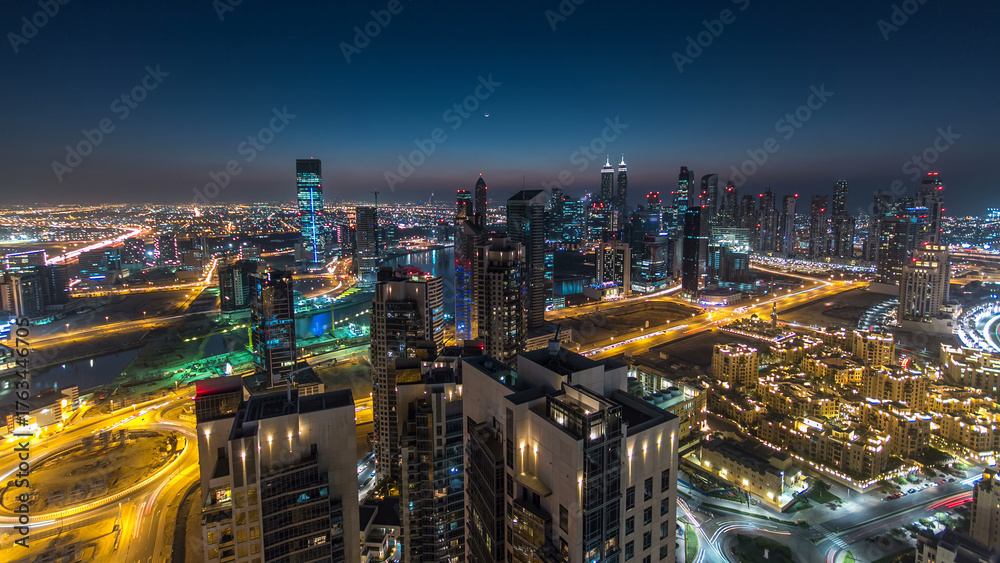 Fototapeta premium Aerial view of a big modern city day to night timelapse. Business bay, Dubai, United Arab Emirates.