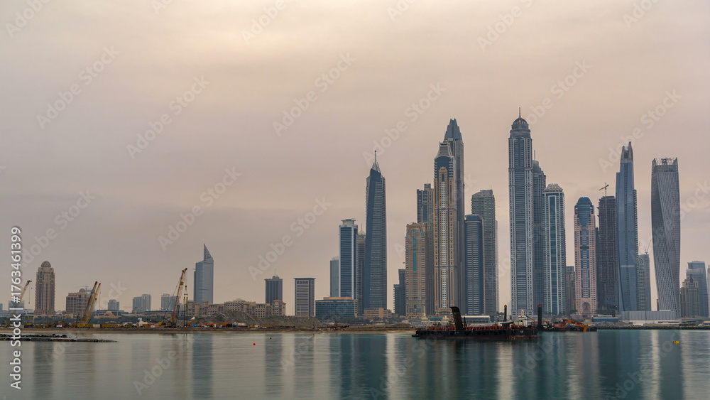 Naklejka premium Panorama of modern skyscrapers in Dubai city at sunrise timelapse from the Palm Jumeirah Island.