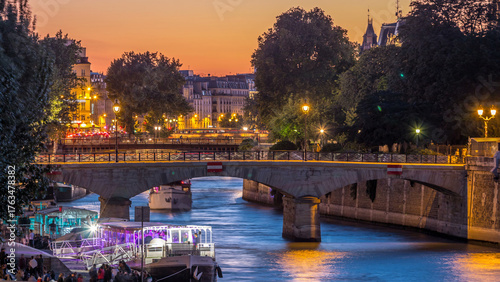 Fotografie River and bridge near Notre Dame De Paris cathedral day to night timelapse after sunset
