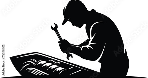 Silhouette of a mechanic working on a car engine with a wrench