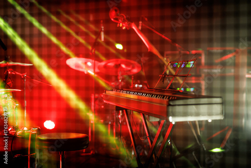 Red-lit stage with keyboard, drums, and double bass
