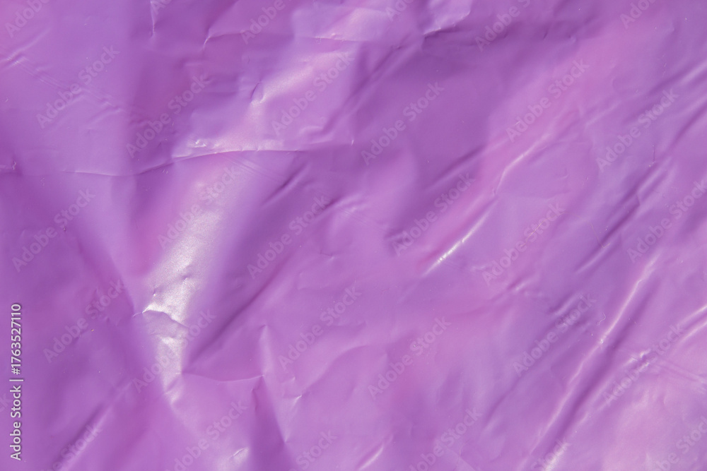 Fototapeta premium Bright purple plastic wrap sheet surface with creases and folds background
