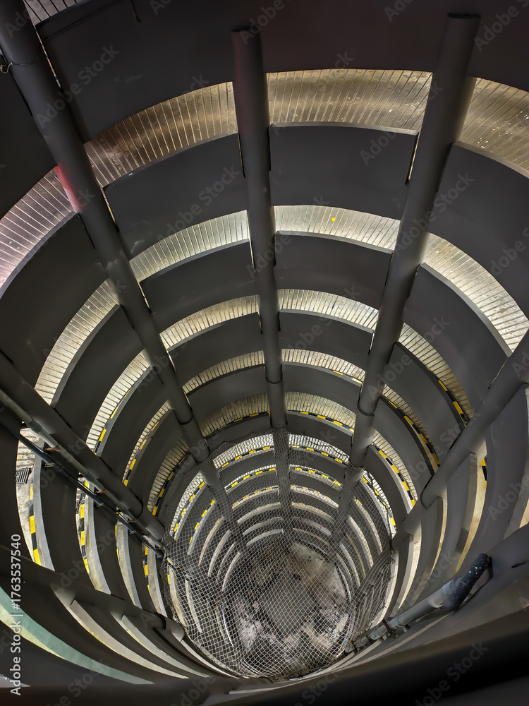 Obraz premium Spiral parking garage ramp with safety net.