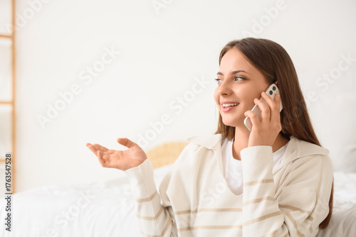 Young woman talking by mobi...