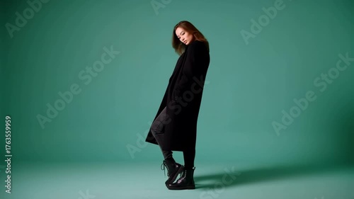 Model poses in stylish outfit against a vibrant green background in a modern studio setting.