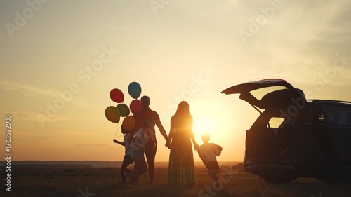 Family playing in the car camping. Adventure travel family concept. A group of children are playing and running around with balloons. A family playing with lifestyle balloons while traveling camping.