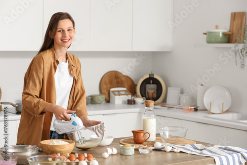 Young woman whipping eggs w...
